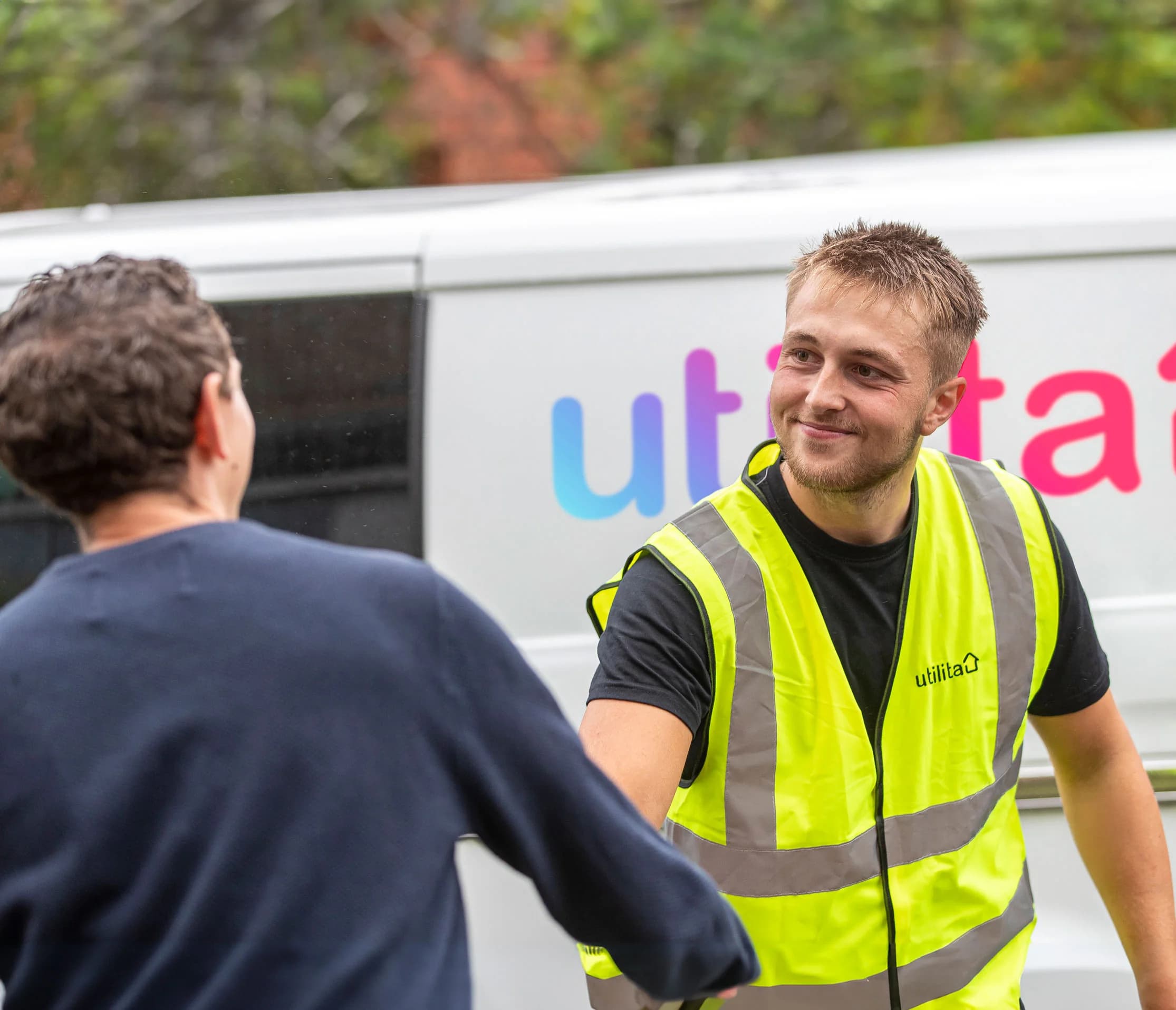 An image of a Utilita Home solar engineer shaking hands with a customer after a solar panel install.