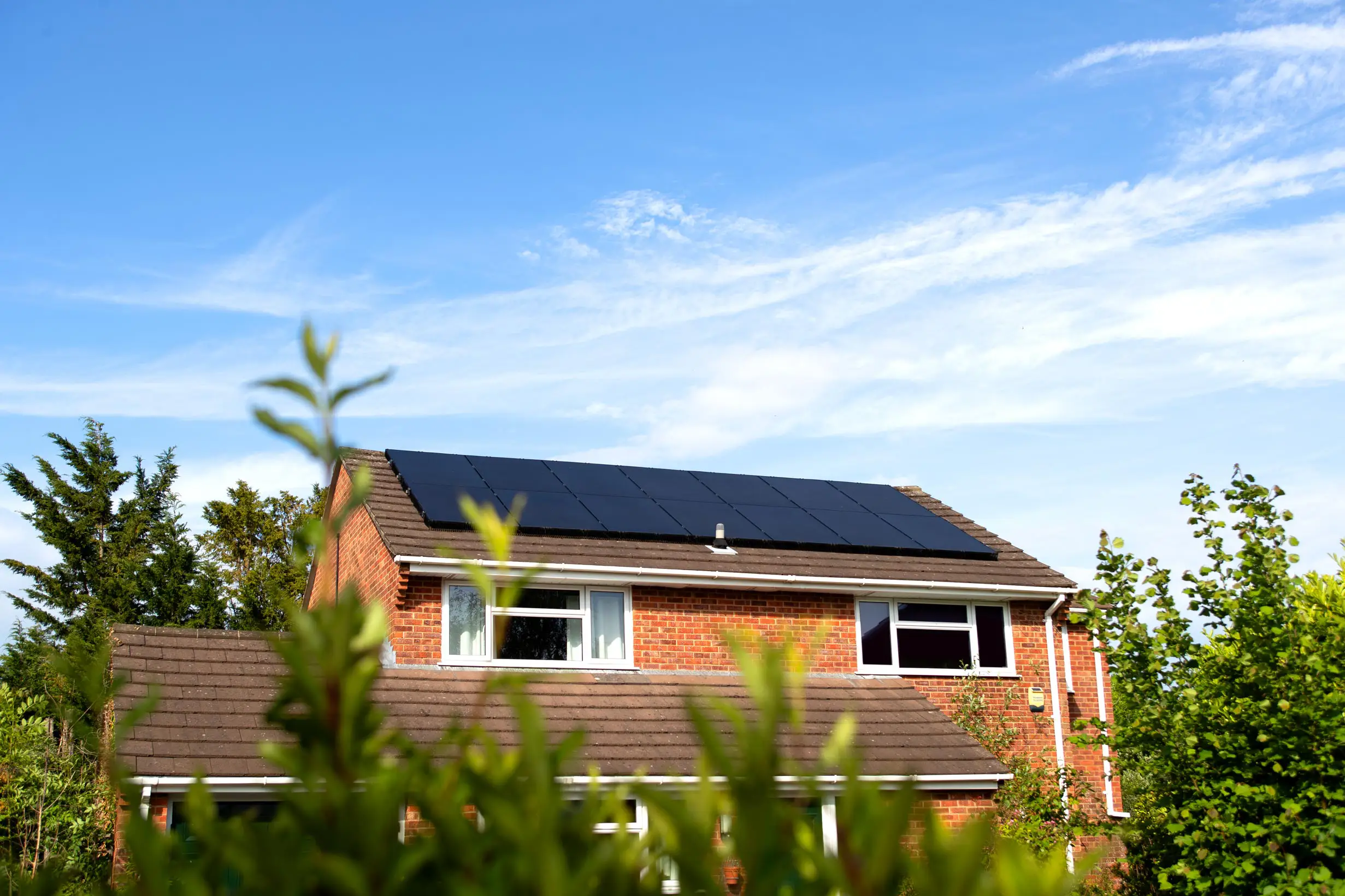 Image of a house with 14 solar panels, representing the benefits of solar to cut carbon & cut costs with Utilita Home.